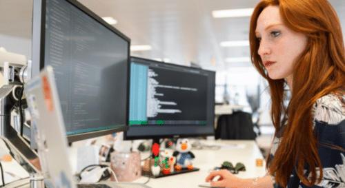 woman writing code on computer