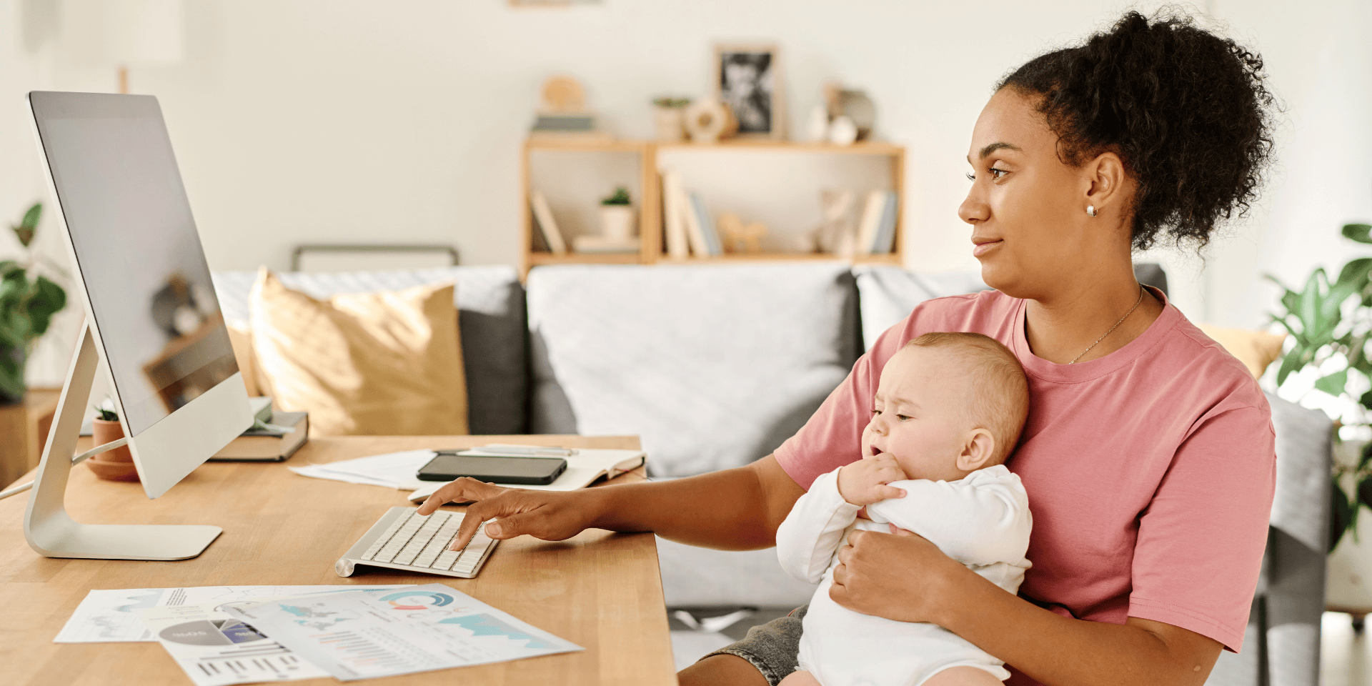 Parent working remotely with baby at home, reflecting work-life balance.