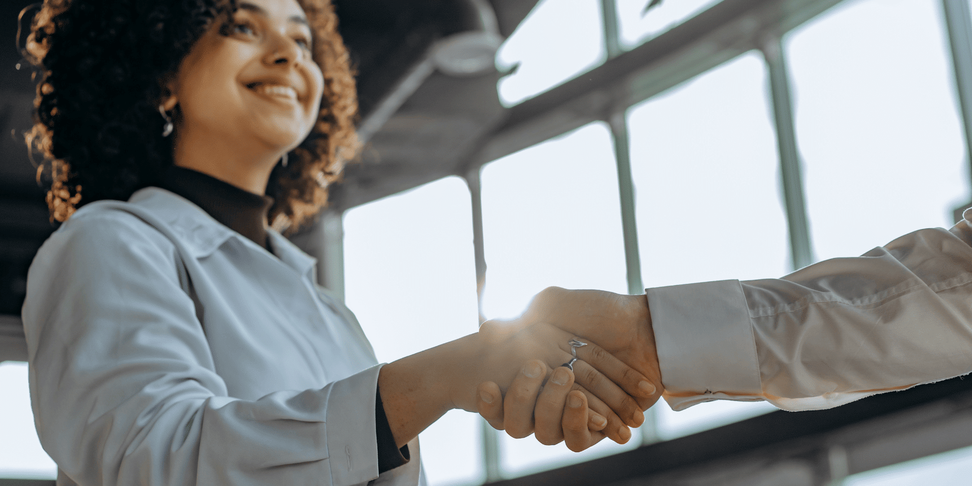 Woman shaking hands after a successful negotiation in tech.