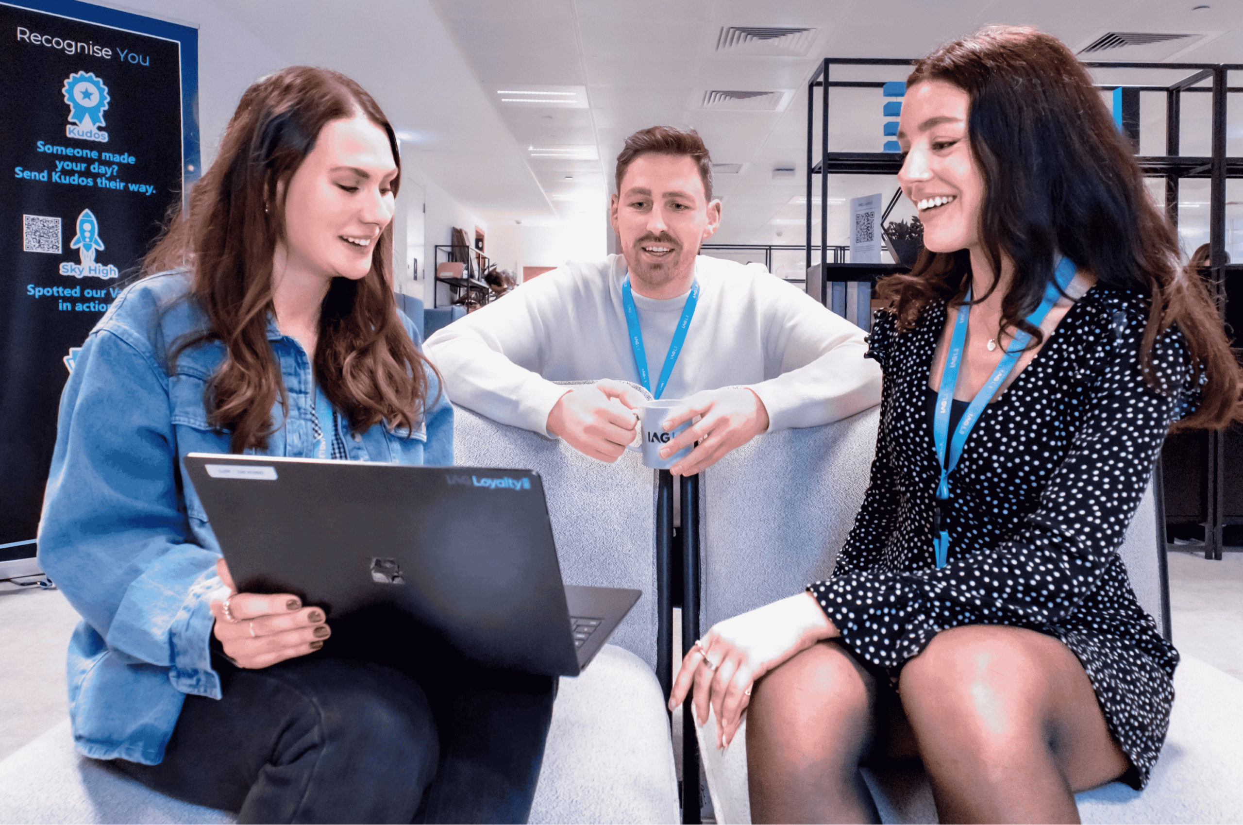 Jess Hunt with two IAG Loyalty colleagues in a collaborative workspace - showcasing diversity in tech teams