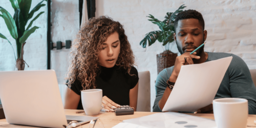 Woman planning a tech startup budget with laptop and notes.